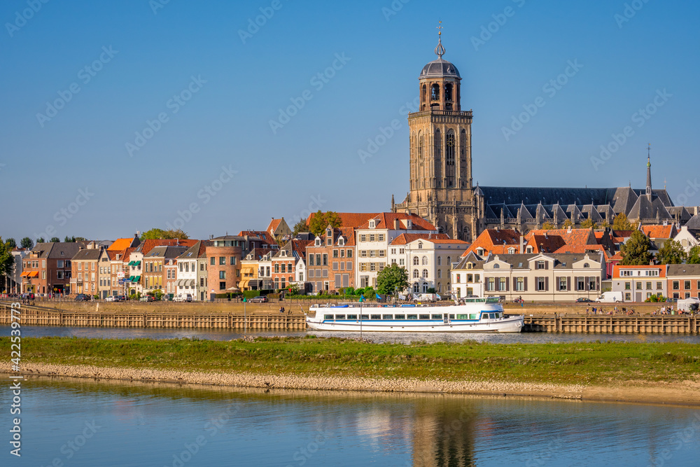 Dutch landschape near the Hanze city of Deventer. The famous Wilhelmina Bridge and the St. Nicholas Church or the Berg Church can be seen. It is a warm and clear summer September day. 