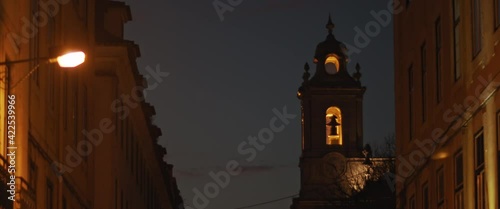 Medieval clock tower in the street of Lisbon at night. Slow motion.