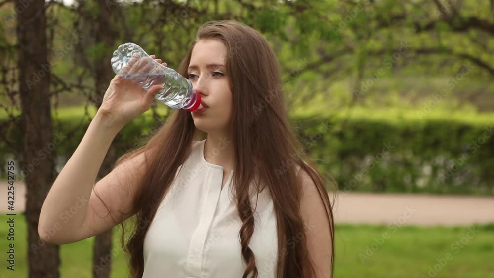 Beautiful woman or girl quenches thirst on a hot sunny day. Beautiful woman or girl quenches thirst on a hot sunny day.