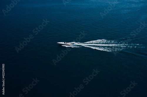 Aerial view luxury motor boat. Travel - image. Drone view of a boat the blue clear waters. Drone view of a boat sailing.