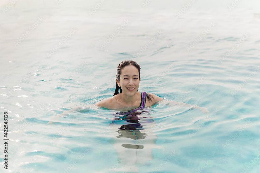 Beautiful asian woman smiling in swimming pool on summer vacation. Beautiful asian woman smiling in swimming pool on summer vacation.