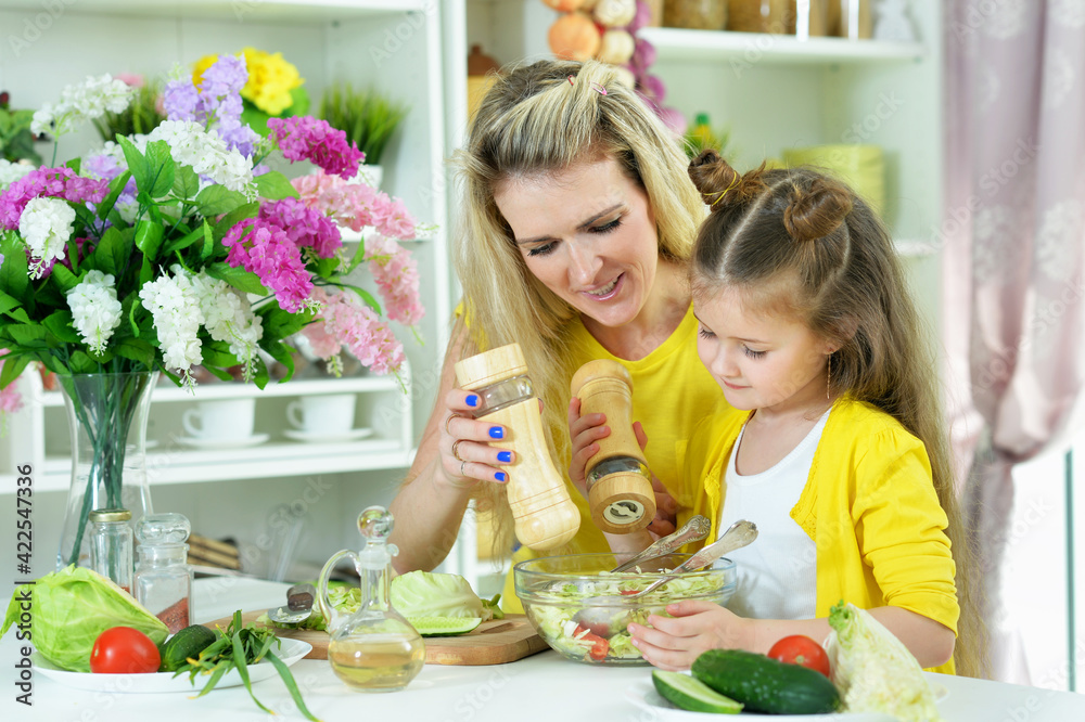 smiling mother and daughter cooking together smiling mother and daughter cooking together