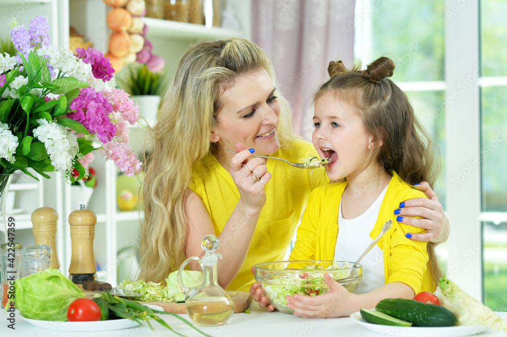 smiling mother and daughter cooking together smiling mother and daughter cooking together
