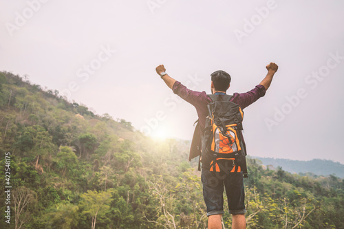 Tourist caucasian man backpacking raise hands feel the sun shining in the evening, successful concept.