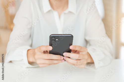 woman work using cell phone hand holding mobile texting message contact us.chatting,search internet information in office.technology device communication connecting © panitan