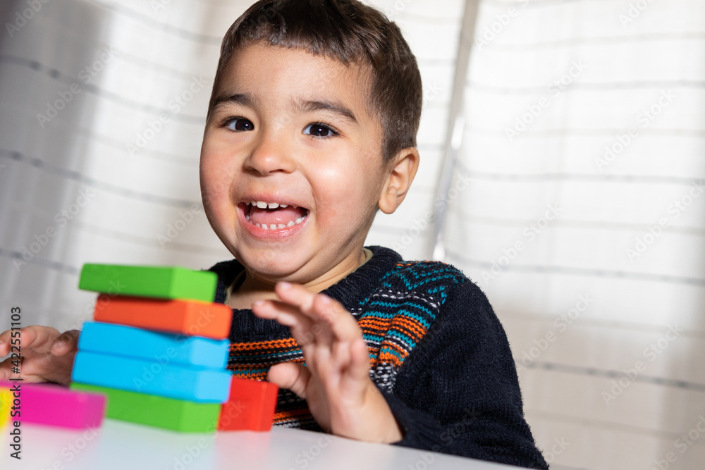 Happy child playing building blocks. Playing and learning at home. Building blocks. Creativity concept. Happy child playing building blocks. Playing and learning at home. Building blocks. Creativity concept.