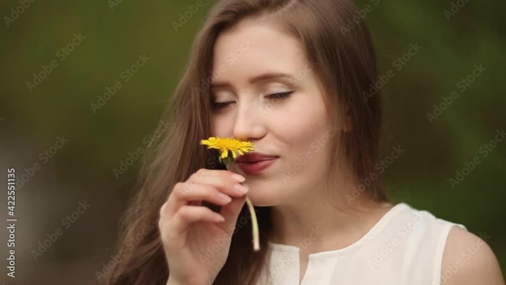 A woman plays with yellow dandelion in her hands A woman plays with yellow dandelion in her hands