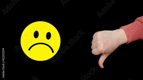 Yellow unhappy dissatisfied smile face and thumbs down showing negative opinion on black background. Yellow sad smile and thumbs down with negative emotion icon photo