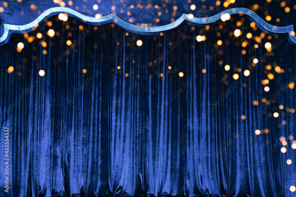 The blue curtain made of luxurious velvet on the stage of the theater is fantastically