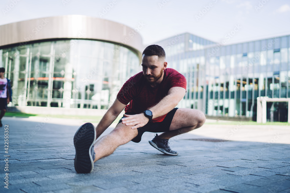 Man doing stretching exercise on street Man doing stretching exercise on street