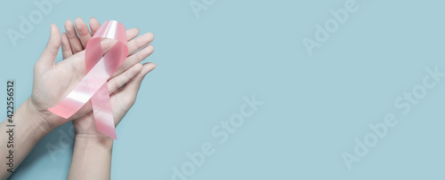 woman hands holding pink ribbon, breast cancer awareness, October pink, World cancer day concept