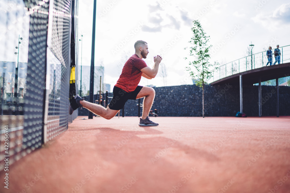 Fototapeta premium Young sportsman doing resistance training on sports ground