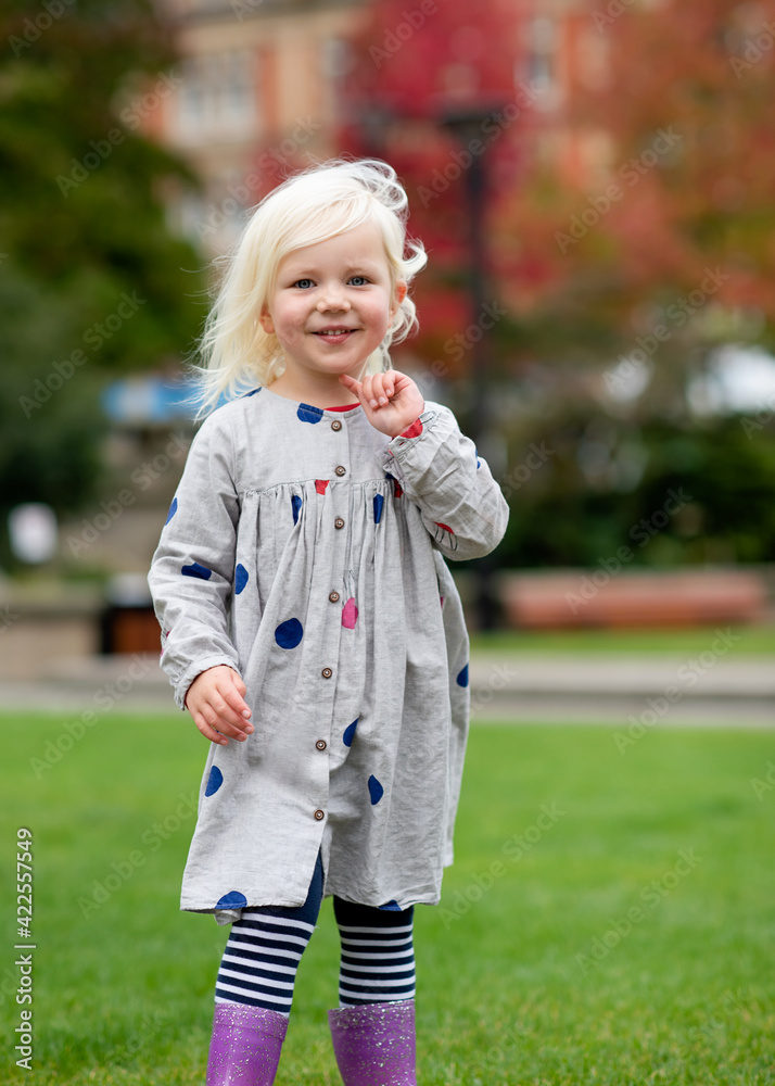 Fototapeta premium A little girl fooling and walking around in a city