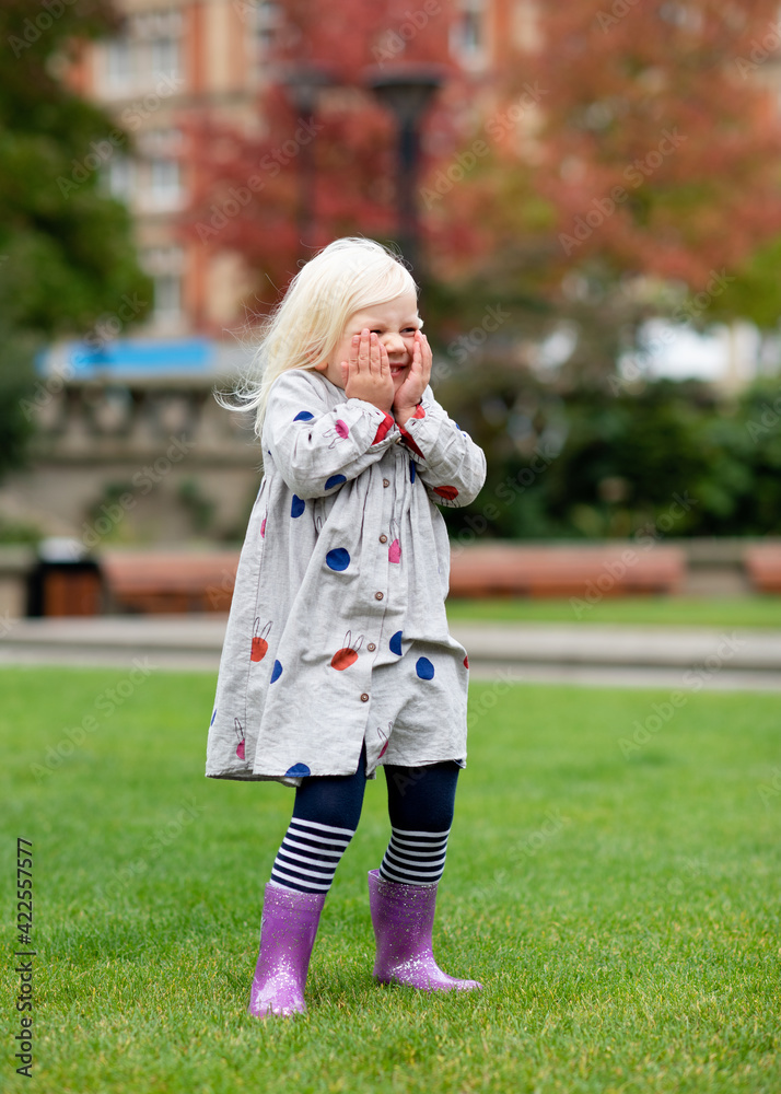 Fototapeta premium A little girl fooling and walking around in a city
