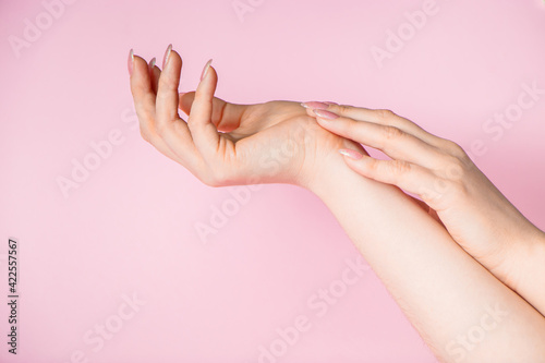 Beautiful female hands on pink background. Spa and body care concept. Image for advertising.