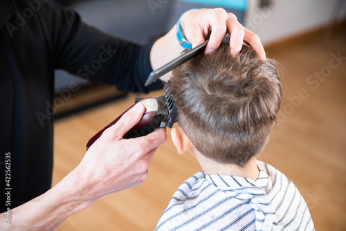 A little boy cutting his hair. Hairdresser cutting a child's hair