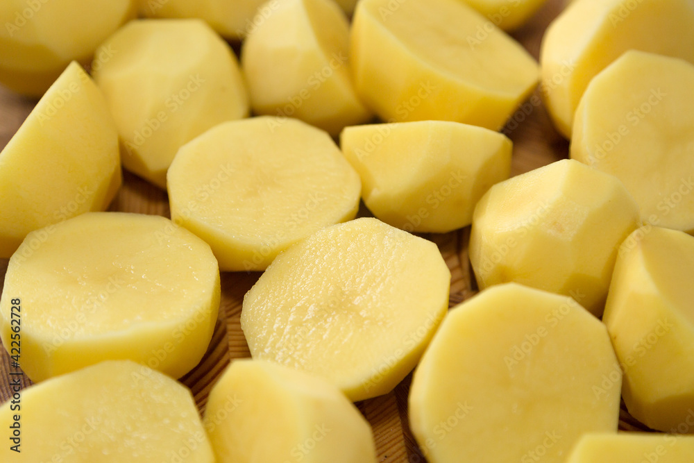 Coarsely chopped potatoes for cooking on wood board. Close-up