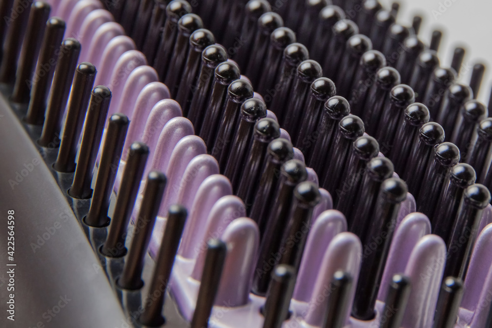 Obraz premium Background image of black and purple bristles of an electric heat brush for straightening hair