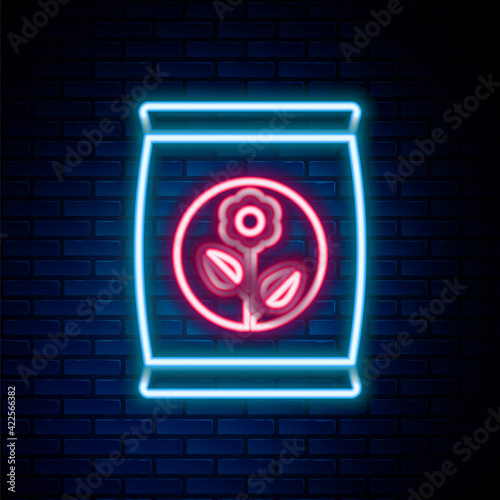 Glowing neon line Fertilizer bag icon isolated on brick wall background. Colorful outline concept. Vector