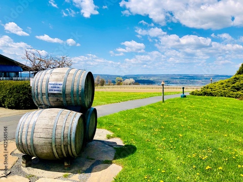 Three wooden wine barrels stacked outside of a winery, on lakeshore of Seneca Lake, in the Finger Lakes Wine Country, New York  © RedBridge