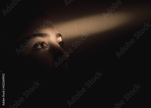 Konstfotografi Single ray of light falling over girls eyes