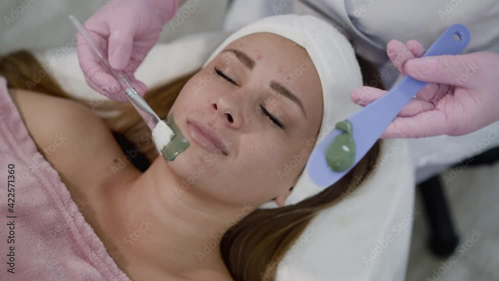 Pretty girl lying on a couch during a beauty treatment of applying the mask Pretty girl lying on a couch during a beauty treatment of applying the mask