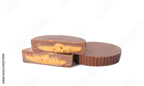 Cut and whole delicious peanut butter cups on white background