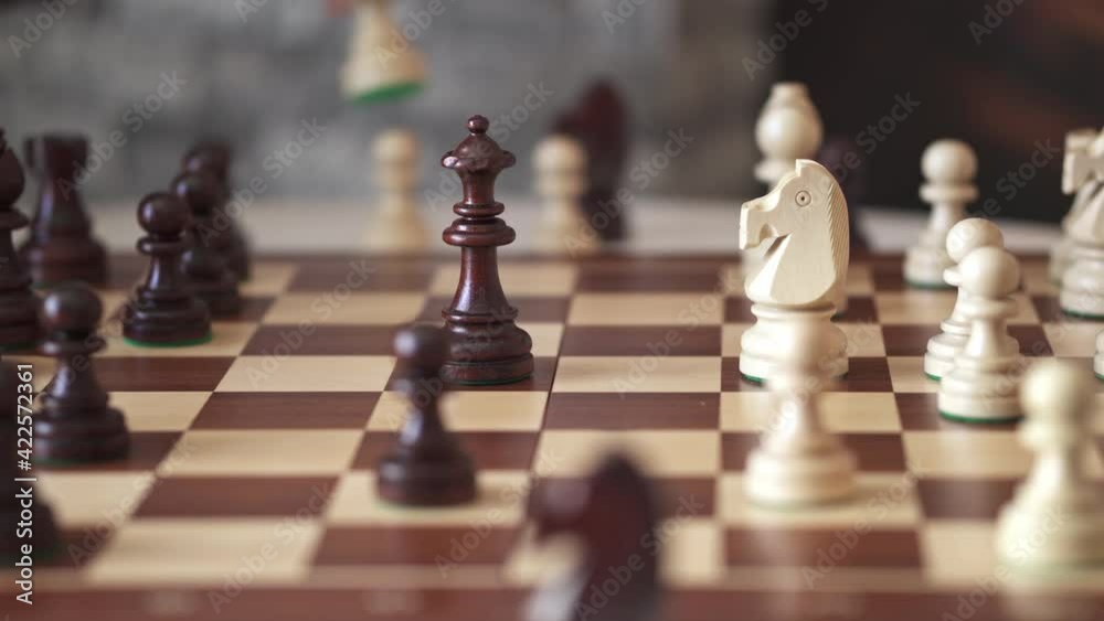 Board chess game side view execution of a move by a player grandmaster. chessboard wooden board figures are made of wood Board chess game side view execution of a move by a player grandmaster. chessboard wooden board figures are made of wood