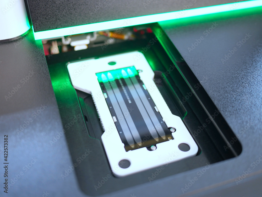 next generation sequencing flow cell in DNA sequencer. genetic engineering, genetic modification, designer baby and cloning concept. cancer screening and medical technology and therapy
