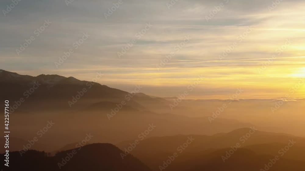 Establishing aerial view of a beautiful mountain landscape silhouette at sunset Establishing aerial view of a beautiful mountain landscape silhouette at sunset