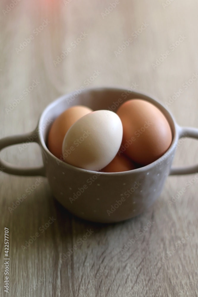 Ceramic bowl filled with fresh free range eggs on wooden table. Selective focus. Ceramic bowl filled with fresh free range eggs on wooden table. Selective focus.