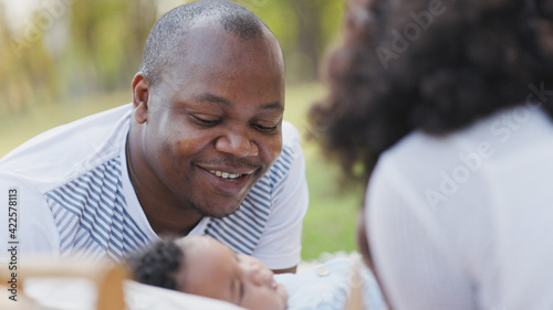 African American family Parents take care of cute baby in garden of house. Happy baby daughter. Father and mother Smile feel relax in playing with children. Concept Family health care insurance