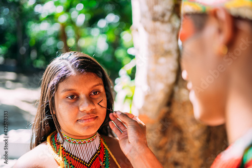 Portrait of young girl indigenous Pataxó ethnicity doing face painting