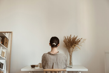 Working at home concept. Girl working at home. Modern home living room interior design. Girl boss, lady boss..Aesthetic minimalist workspace background. Blog, social media, web, magazine template.