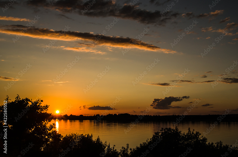 Sunset. Orange sky. Reflection in the river. Horizon