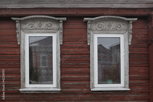 Ornamental carved windows, frames on brown traditional national old wooden rural house in Gorodets city, Russia. Russian folk style in architecture. Gorodets architectural monument, Gorodets landmark photo