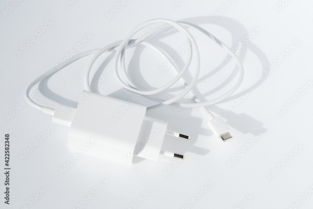Cable plug usb charger on white background, top view. Minimalistic technology concept