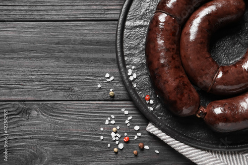 Tasty blood sausages served on black wooden table, flat lay. Space for text