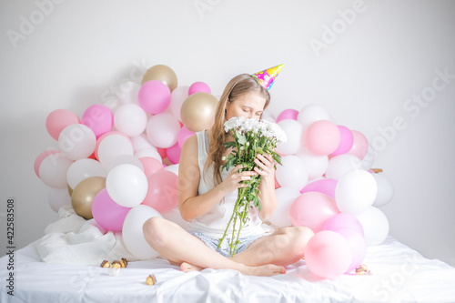 Young beautiful girl woke up surrounded by balloons on Birthday Day