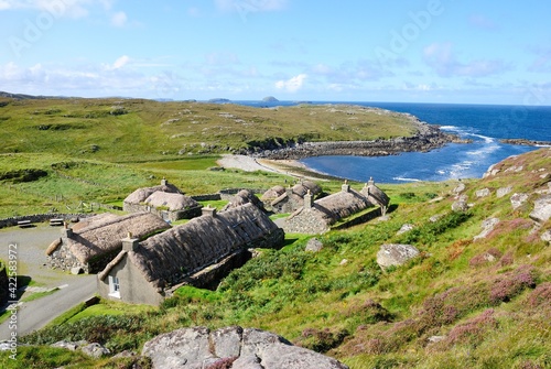 Garenin blackhouse village on the west coast of the Isle of Lewis in the Outer Hebrides of Scotland, UK on a beautiful sunny day with a view of a Garenin bay photo