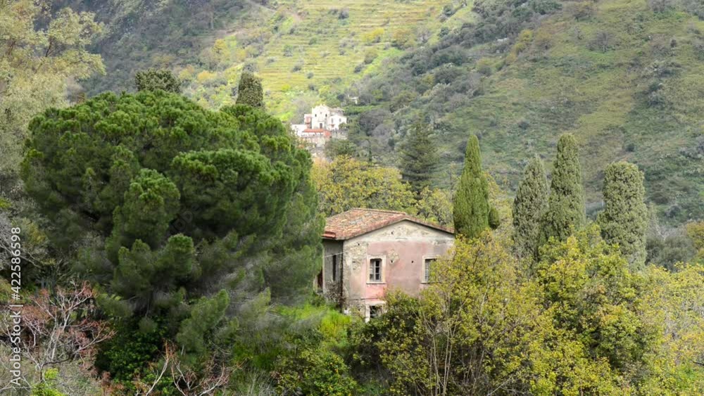 an abandoned house in the mountains of Eastern Sicily with spring vegetation and other distant houses among the reliefs an abandoned house in the mountains of Eastern Sicily with spring vegetation and other distant houses among the reliefs