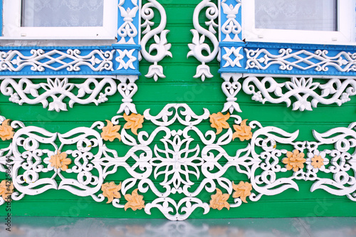 Detail of old traditional national rural wooden house with ornamental carved windows, frames in Purekh village (Nizhny Novgorod region, Russia). Russian folk style in architecture photo