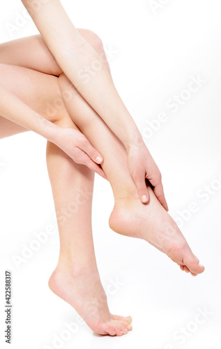 beautiful graceful female legs of young woman over white background