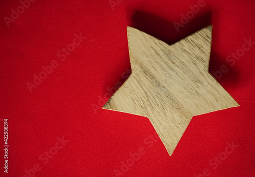 pentagram. wooden star lie on red background. empty copy space for inscription. photo