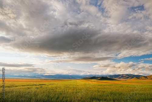 Fields and open spaces in the steppes of Tuva against the background of sunset clouds in autumn it is time to harvest cereals