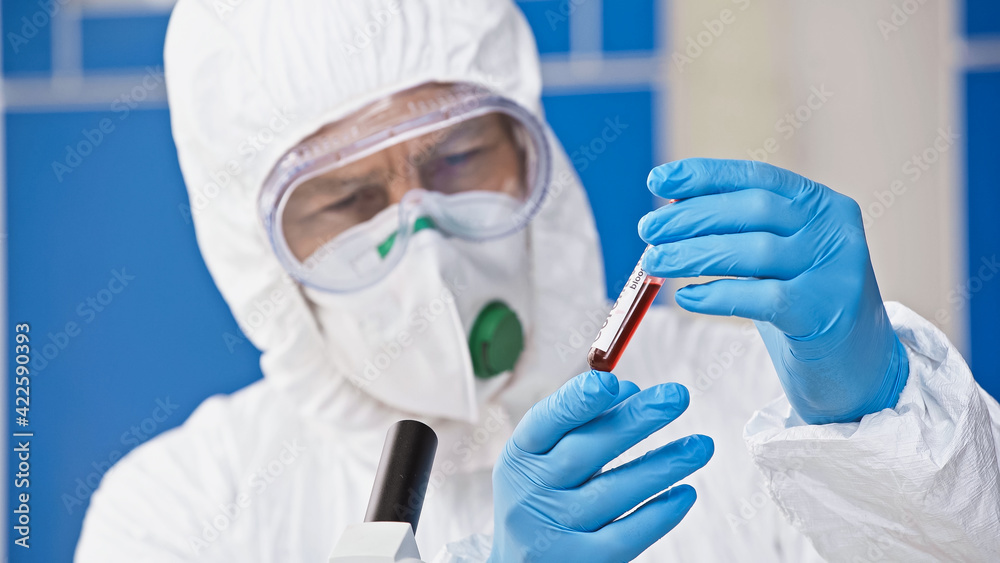 virologist holding test tube with blood sample in laboratory, blurred background virologist holding test tube with blood sample in laboratory, blurred background