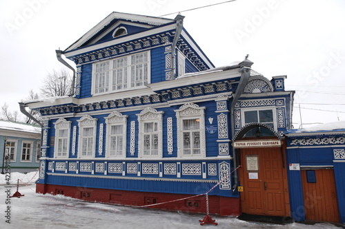 Vintage wooden house with ornamental carved windows, frames in Gorodets town, Nizhny Novgorod region, Russia. Russian style in vintage architecture. Museum of samovars. Gorodets landmark, monument photo