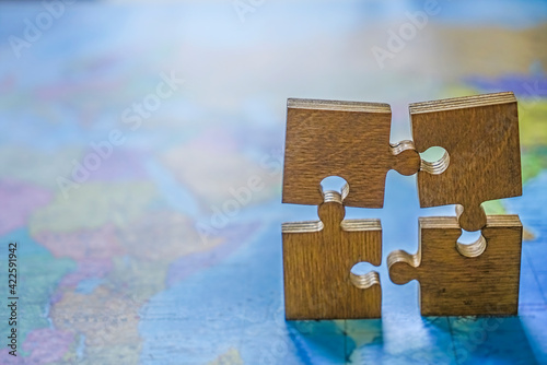 four 4 wooden puzzle on world map background. empty copy space for inscription or other objects. Concept of Globalization. photo