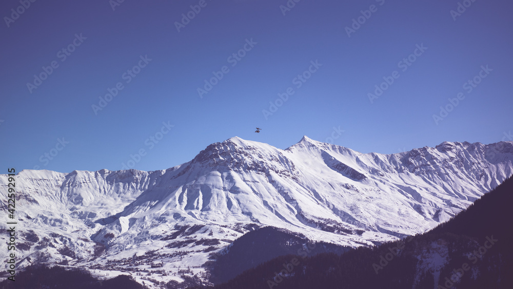 ULM en vol adns un ciel bleu devant les montagnes de Savoie