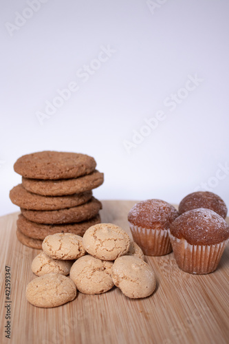 muffins, almond amaretti and oat cookies on wooden stand board. sweet bakery concept